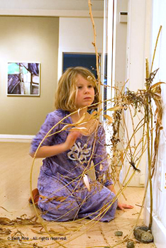 girl working on sculpture with sticks