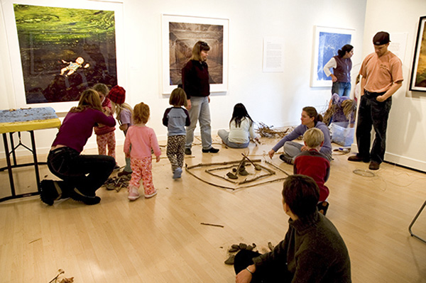 photo of adults and children making art indoors in gallery