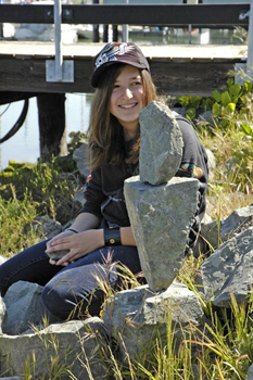 Teen sitting proudly with rock art